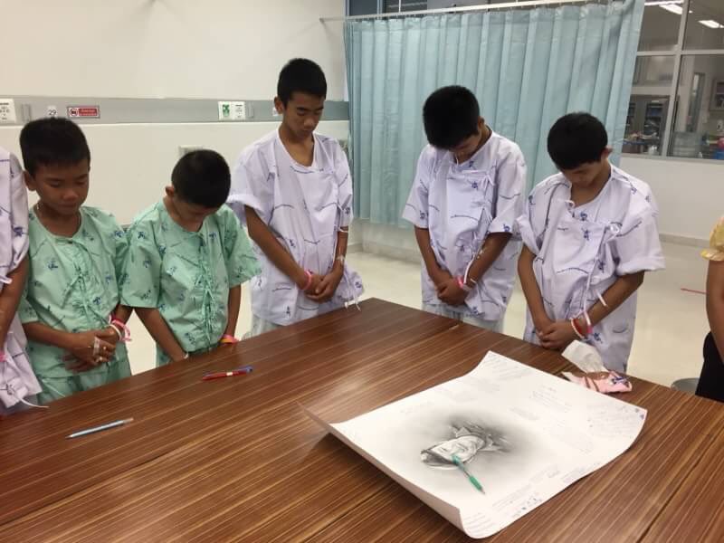 Meninos resgatados de caverna na Tailândia homenageiam mergulhador que faleceu em operação de salvamento. Foto: Chiang Rai Prachanukroh Hospital