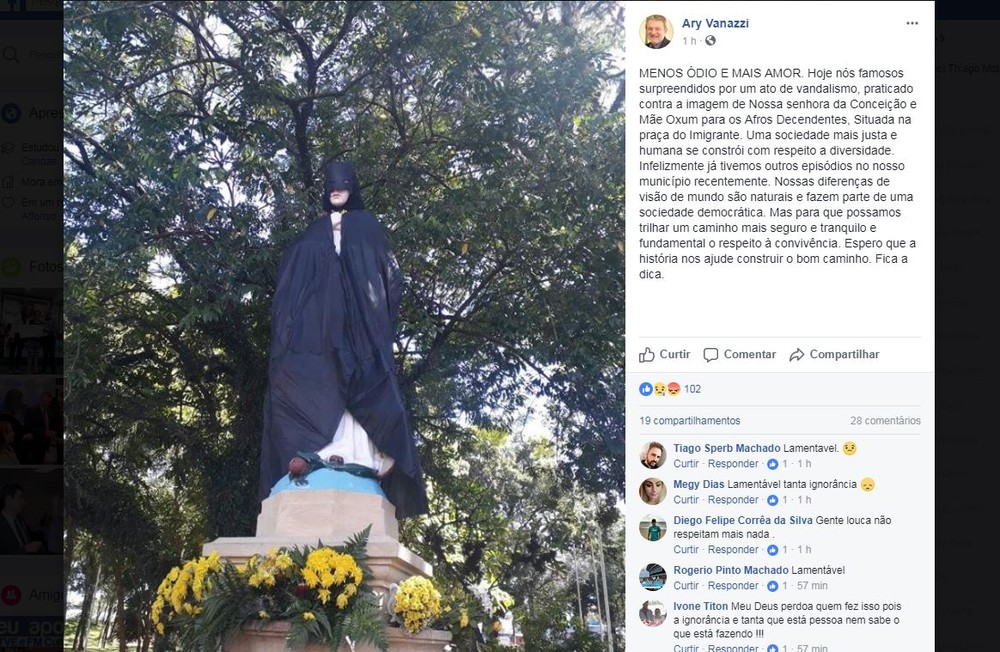 Estátua de santa aparece com capa e máscara do Batman em praça pública