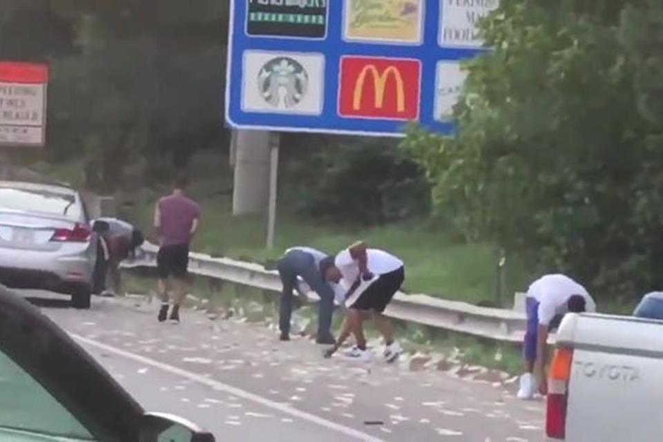 Porta de carro-forte se abre e espalha cerca de R$ 650 mil em rodovia